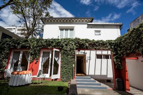 a white house with ivy growing on it at La Rabida Hotel Boutique in Quito