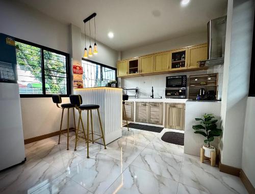 a kitchen with a bar with stools in it at SwanBB in Hang Dong