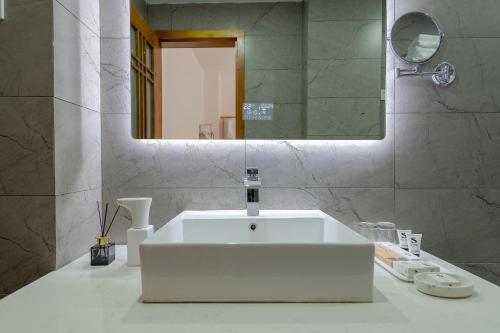 a bathroom with a white sink and a mirror at 丽江慕云堂观景客栈Lijiang Muyuntang View Hotel in Lijiang