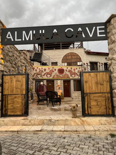 a dog sitting in front of an entrance to a building at Almula Cave in Avanos