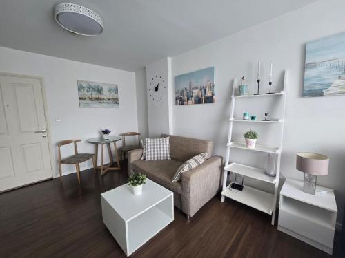 a living room with a couch and a table at Downtown Hua Hin Condo with Pool in Hua Hin