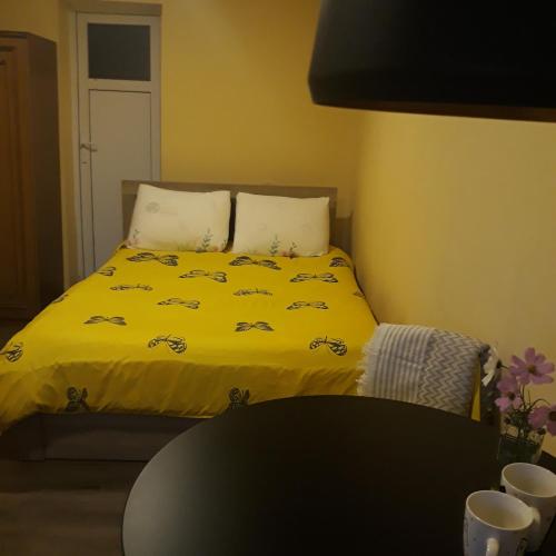 a bedroom with a bed with a yellow blanket at Belas guesthouse in Stepantsminda