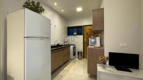 坎波斯杜若尔当Cantinho Dolce Amore的带冰箱的厨房和电视。