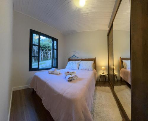 坎波斯杜若尔当Cantinho Dolce Amore的一间卧室，床上有两只毛绒玩具