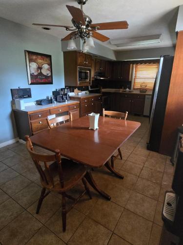 a kitchen with a wooden table with chairs and a ceiling fan at La Casa delle Pesche in Georgetown