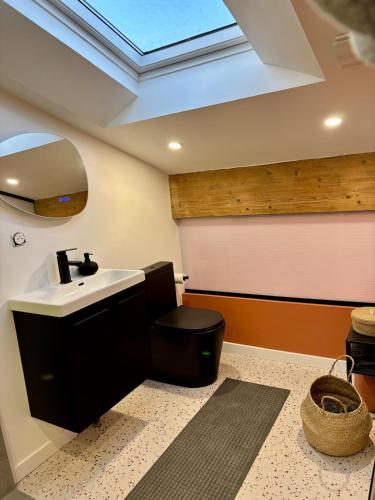 Un baño con lavabo, inodoro y tragaluz. en Charming apartment!, en Castillon-Savès