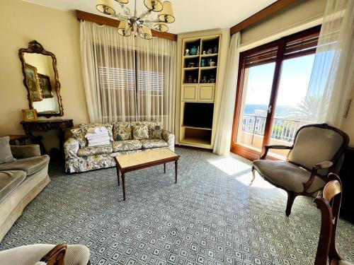 a living room with a couch and a chair at Suite A 2 passi dalla Spiaggia - Ospedaletti in Ospedaletti