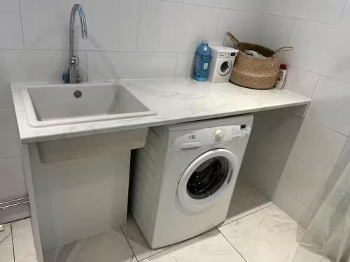 a kitchen with a sink and a washing machine at Guest House Near Linnaeus University in Växjö