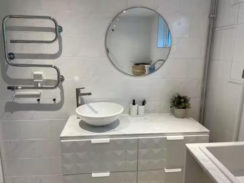 a white bathroom with a sink and a mirror at Guest House Near Linnaeus University in Växjö