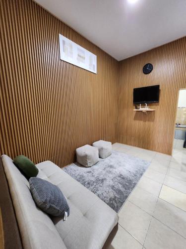 a living room with a couch and a television at Anugrah 2 Syariah Homestay Ciperna in Ciperna