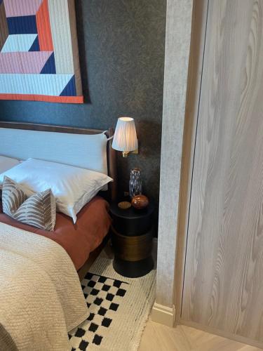 a bedroom with a bed and a table with a lamp at London Residence in London