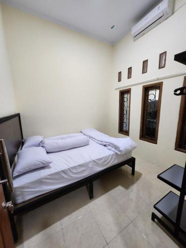 a room with a bed with pillows on it at Anugrah 2 Syariah Homestay Ciperna in Ciperna