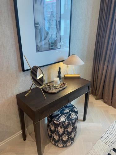 a table with a mirror and a lamp on it at London Residence in London