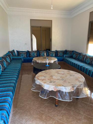 a living room with a blue couch and two tables at Villa zaytoun in Agadir