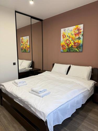 a bedroom with a white bed with two towels on it at Апартаменти ВІП вул Під Голоском 15 б 9-1 in Lviv