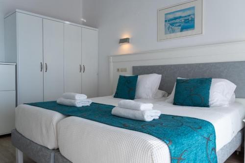 a bedroom with two beds with towels on them at Rethymno Mare & Water Park in Rethymno Town