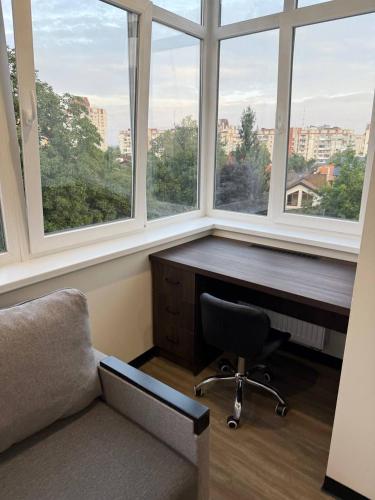 a office with a desk and a chair and windows at Апартаменти ВІП вул Під Голоском 15 б 9-1 in Lviv