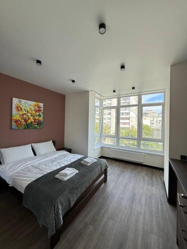 a bedroom with a large bed and a large window at Апартаменти ВІП вул Під Голоском 15 б 9-1 in Lviv