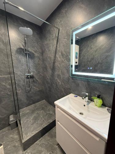 a bathroom with a shower and a sink and a mirror at Апартаменти ВІП вул Під Голоском 15 б 9-1 in Lviv