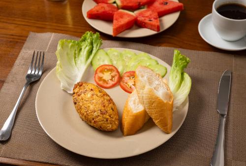un plato de comida con un sándwich y verduras y una taza de café en Tam Coc Condelux Boutique Hotel, en Ninh Binh