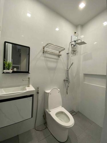 a white bathroom with a toilet and a sink at three x apartelle in Tagbilaran City
