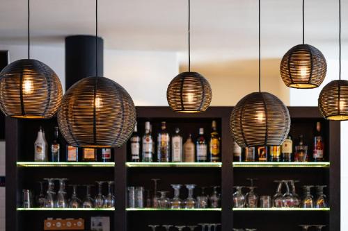a bar with several lights and a shelf with bottles at Holiday Inn Express Mechelen City Centre by IHG in Mechelen