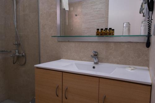 a bathroom with a sink and a shower at Rethymno Mare & Water Park in Rethymno Town