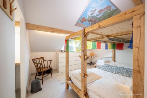 a bedroom with a bunk bed and a chair at Maison Outhera - Chambre d'hôtes in Orcières