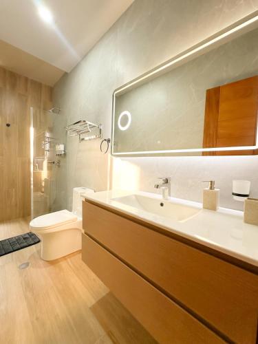 プカルパにあるAlma Residenceの洗面台、トイレ、鏡のあるバスルーム