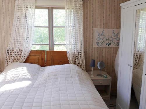 a bedroom with a white bed and a window at 4 person holiday home in BRUA KULLA-By Traum in Källekulla