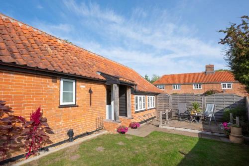 a brick house with a garden and a fence at Marlborough House Forge in Saxtead