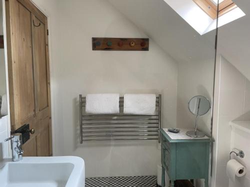 a bathroom with a sink and a towel rack at The Shed in Stratford-upon-Avon