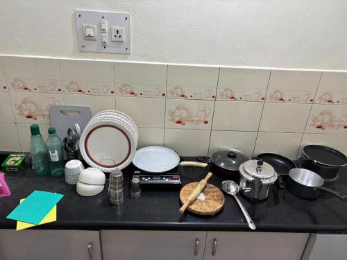 a kitchen counter top with pots and pans on it at Sihi 2BHK in Mysore