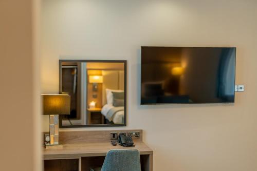a room with a desk with a lamp and a mirror at Ashorne Hill Leamington Spa in Leamington Spa