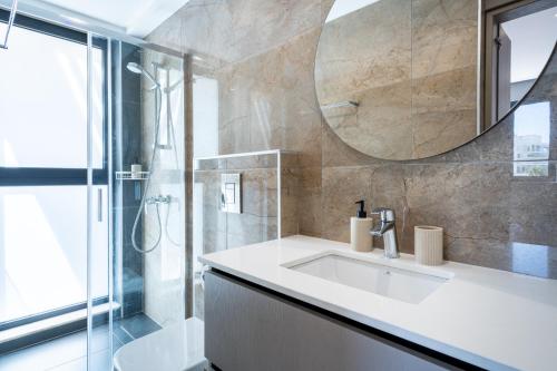 a bathroom with a sink and a shower and a mirror at Itero 2-Bedroom Luxury Apartment in Larnaka