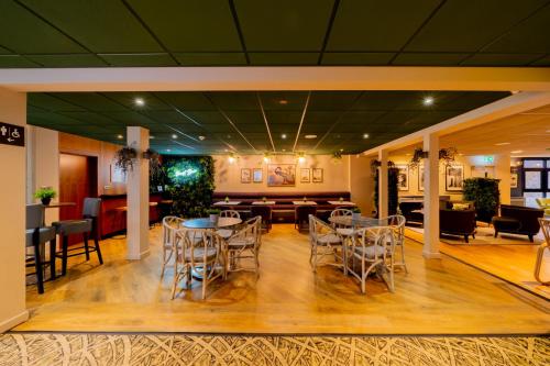 a lobby with tables and chairs and a bar at Ashorne Hill Leamington Spa in Leamington Spa