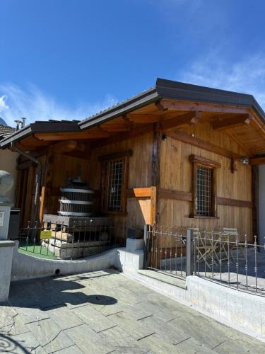 a wooden building with a fence in front of it at La maison de vali in Aosta