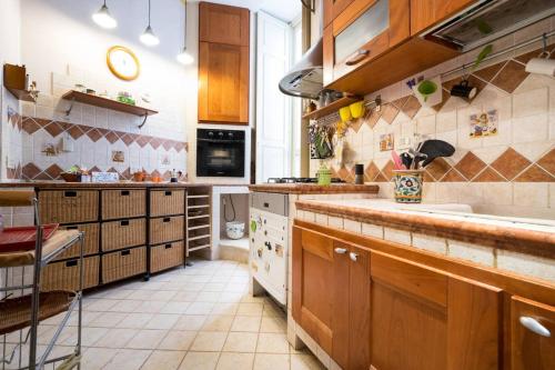 a large kitchen with wooden cabinets and a counter top at Regina Reginella in Siracusa