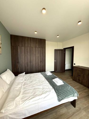 a bedroom with a large white bed with a wooden headboard at Апартаменти ВІП вул Під Голоском 15 б 9-2 in Lviv