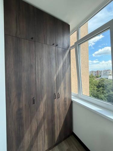 a room with wooden cabinets and a window at Апартаменти ВІП вул Під Голоском 15 б 9-2 in Lviv