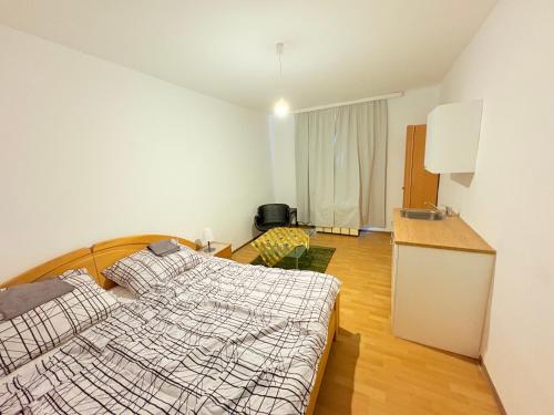 Un dormitorio con una cama y una cocina con fregadero. en Beenie, en Linz