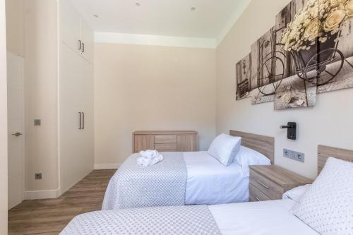 two beds in a room with white walls at Hospital Cruces Metro Bec in Barakaldo