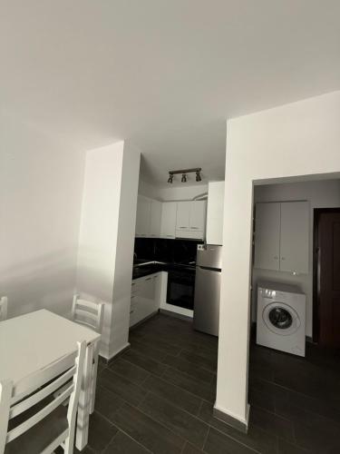 a white kitchen with a washing machine and a washer at Caca Apartments in Golem