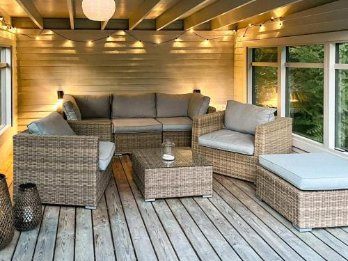 une terrasse en bois avec des meubles en osier dans l'établissement 6 person holiday home in Gilleleje-By Traum, à Gilleleje