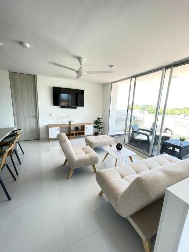 a living room with a couch and chairs and a tv at Condominio Ricaurte in Ricaurte