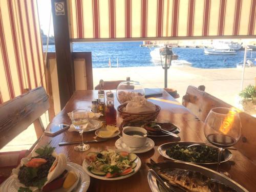 a table with plates of food and a view of the ocean at Villa Lav in Prigradica