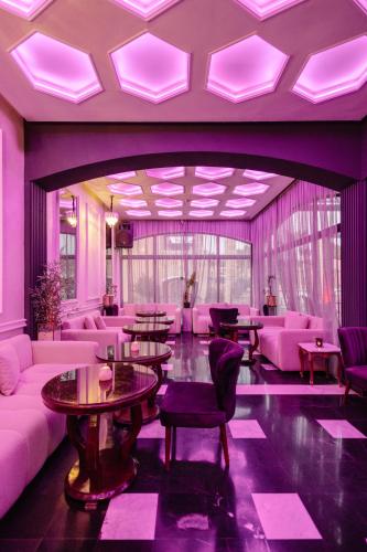 a lobby with pink furniture and tables and purple lighting at Hotel Prestige Agadir Boutique & SPA in Agadir