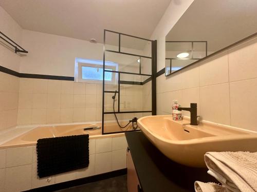 a bathroom with a sink and a bath tub at La Floraison - 2 personnes in Molesmes