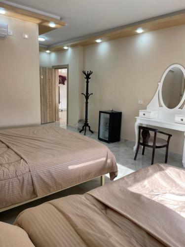 a bedroom with two beds and a mirror and a sink at Airport Villa Amman in Amman