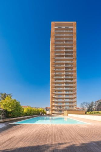 a tall building with a swimming pool in front of a building at GiaxTower Gym Spa & Pool Romantic Pool View in Milan